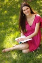 Cheerful attractive student teen girl reading book outdoor Royalty Free Stock Photo