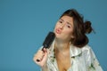 Cheerful attractive teen girl sing song holding comb like a microphone in the morning