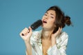 Cheerful attractive teen girl sing song holding comb like a microphone in the morning