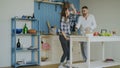 Cheerful and attractive young couple in love dancing together rocknroll dance in the kitchen at home on holidays