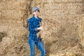 Young female farmer standing in hayloft with hay in hands Royalty Free Stock Photo
