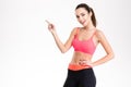 Cheerful attractive young fitness woman pointing away Royalty Free Stock Photo