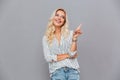 Cheerful attractive young woman pointing finger away Royalty Free Stock Photo