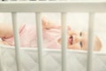 Cheerful baby girl lying in crib at home Royalty Free Stock Photo