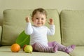 Cheerful baby girl plays with fruits at home Royalty Free Stock Photo