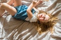 Cheerful baby laughing. cheerful girl lies on the bed and screams with joy