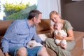 Cheerful baby looking to her father while mom is holding her. Family at home Royalty Free Stock Photo