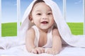 Cheerful baby playing with towel on bed Royalty Free Stock Photo