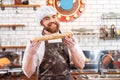 Cheerful baker showing loaf of bread on the kitchen Royalty Free Stock Photo