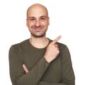 Cheerful bald guy is pointing finger to copy space