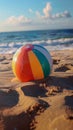 Cheerful beach ball rests on sun kissed sand, epitome of summer