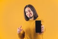 Cheerful bearded caucasian man showing his smartphone with blank screen. Technology concept. Studio shot over orange Royalty Free Stock Photo