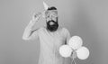 Cheerful bearded man with big smile wearing enormous glasses and birthday cap. Happy hipster with trimmed beard and