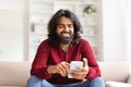 Cheerful bearded man using smartphone at home Royalty Free Stock Photo