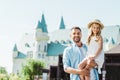 cheerful bearded man holding in arms cute daughter near blue castle.