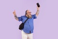 Plus size man with headphones enjoys music on mobile phone on purple background