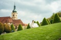 Cheerful beautiful bride is spinning round on the meadow at the background of the old buildings of Prague. Royalty Free Stock Photo