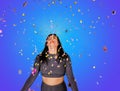 Cheerful beautiful brunette girl blowing confetti from her hands. Celebration of the holiday. Festive New Year& s Royalty Free Stock Photo