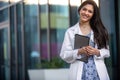 Cheerful beautiful brunette medical student or intern at dental, psychiatry, pharmaceutical job, smiling with electronic tablet Royalty Free Stock Photo