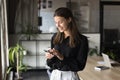 Cheerful beautiful businesswoman typing on smartphone, using professional service Royalty Free Stock Photo