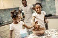 Cheerful beautiful daughters feeling amazing cooking cupcakes