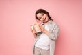 Cheerful beautiful girl smiling and laughing holding a small gift with a bow and tilting her head to one side Royalty Free Stock Photo