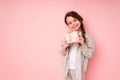 Cheerful beautiful girl smiling and laughing holding a small gift with a bow and tilting her head to one side Royalty Free Stock Photo