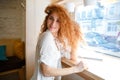 Cheerful beautiful redhead young lady sitting in cafe Royalty Free Stock Photo