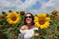 Cheerful beautiful Turkish woman in sunglasses posing on a sunflower field Royalty Free Stock Photo