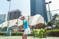 Cheerful beautiful woman playing tennis in a developed city Royalty Free Stock Photo