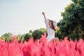 Beautiful young asian woman sitting with raising arms in cockscomb flower blooming in garden Royalty Free Stock Photo
