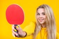 Cheerful beautiful young blonde woman in casual yellow sporty clothes play ping pong, holding a ball and racquet Royalty Free Stock Photo