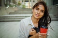 Cheerful beautiful young woman outdoors drinking morning coffee in sunlight Royalty Free Stock Photo