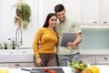 Beautiful young couple looking for recipe on Internet, using tablet Royalty Free Stock Photo