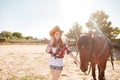 Cheerful beautiful young woman cowgirl with her horse on ranch Royalty Free Stock Photo