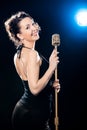 Cheerful beautiful young woman singer holding golden vintage mic Royalty Free Stock Photo