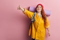 Cheerful beautiful young woman tourist hitchhiking along a road. Royalty Free Stock Photo