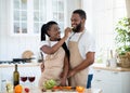 Cheerful black couple cooking and tasting healthy food in kitchen at home Royalty Free Stock Photo