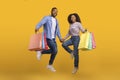 Cheerful Black Couple Holding Hands And Jumping With Shopping Bags Royalty Free Stock Photo