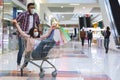 Cheerful black couple in medical masks having fun while shopping in mall Royalty Free Stock Photo