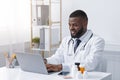 Cheerful black doctor checking on new pills online