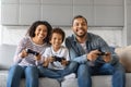 Cheerful Black Family Of Three Competing With Each Other In Video Games