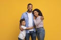 Cheerful black family of three with little son sharing loving embrace Royalty Free Stock Photo