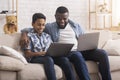 Cheerful Black Father And Son Playing Video Games Online On Laptops Royalty Free Stock Photo