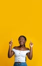 Cheerful Black Female Pointing Up At Copy Space Above Her Head Royalty Free Stock Photo