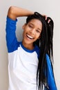 Cheerful black girl with braided hair smiling against a wall Royalty Free Stock Photo