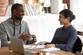 Cheerful black guy discussing project ideas with smiling indian girl. Royalty Free Stock Photo