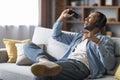 Cheerful Black Guy Listening Music In Wireless Headphones And Singing At Home Royalty Free Stock Photo