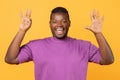 Cheerful black guy raising both hands showing number eight, studio Royalty Free Stock Photo