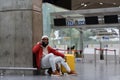 Handsome African man in red jacket calling on smartphone in airport while waiting flight in lounge. Royalty Free Stock Photo